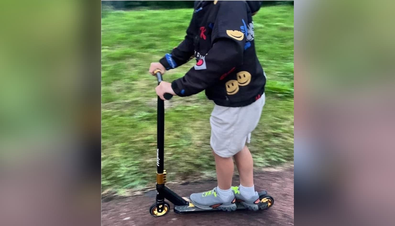 Zwarte stuntstep met goudkleurige velgen tijdens buitenspelen weggenomen in Tolbert