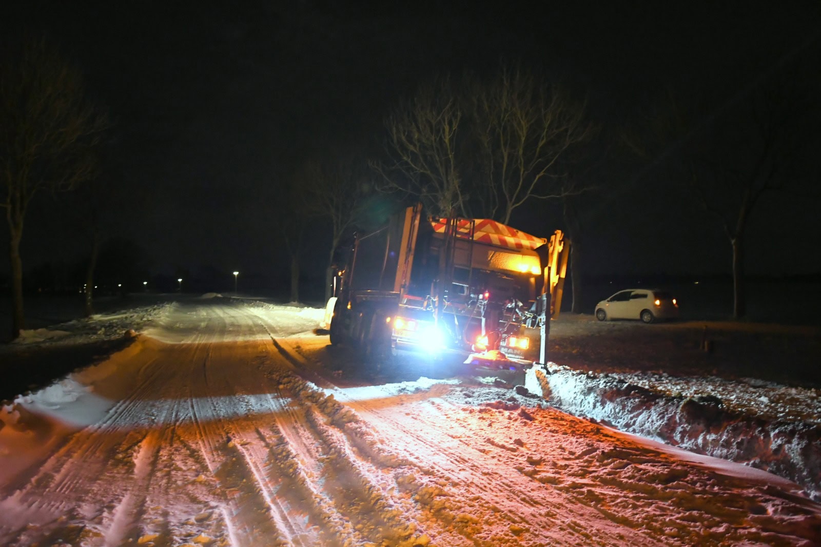 Strooiauto glijdt van de weg en komt vast te zitten in berm langs N980